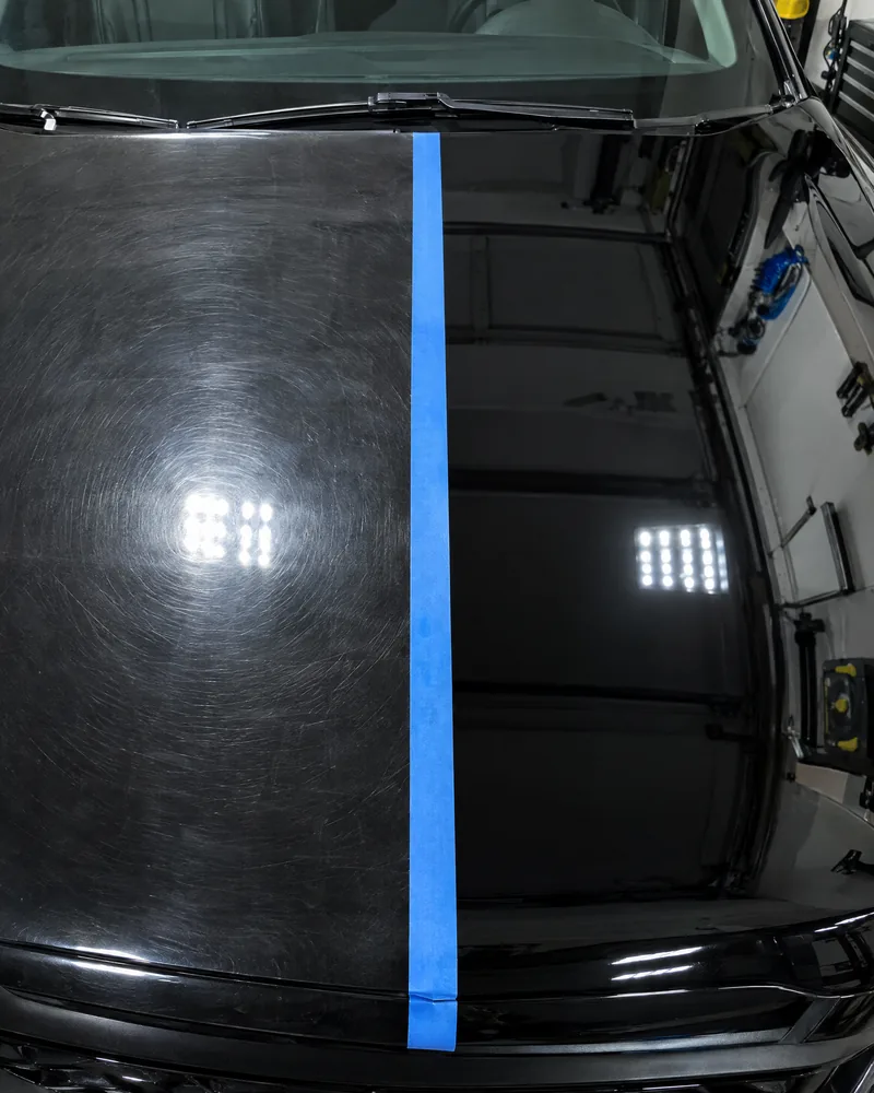 Black bonnet with a blue tape line, swirled on one side and corrected on the other